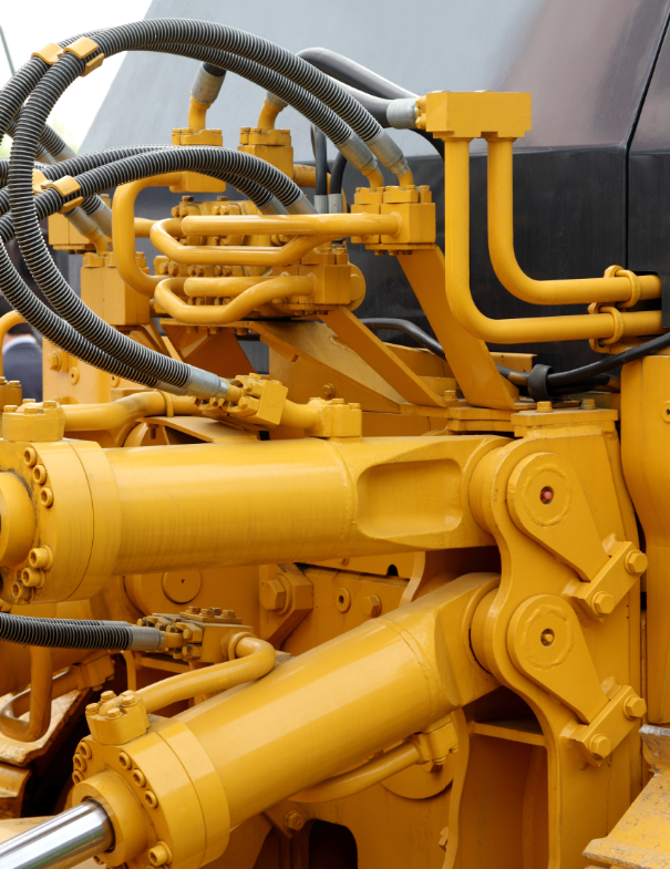 Diesel mechanic repairing the broken hydraulic hose of a heavy earthmoving vehicle